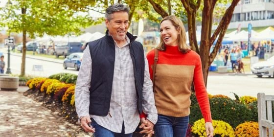 Couple holding hands in winter while walking in Riverwalk Landing