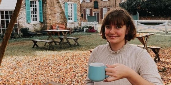 Woman holding a cup of coffee at Mobjack Coffee Roasters