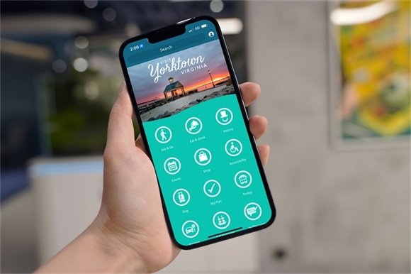 Hand holding phone showing Visit Yorktown widget on screen